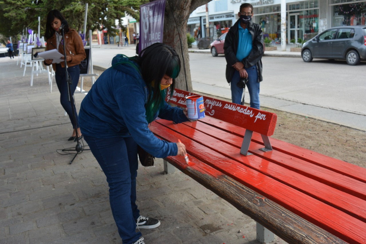 Acto municipal por el Día de la Mujer: En Caleta pintaron el banco rojo N° 302 por los femicidios